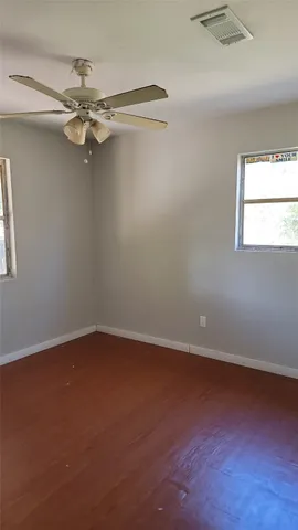 an empty room with a window and a fan