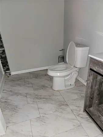 a white toilet sitting next to a shower and a sink