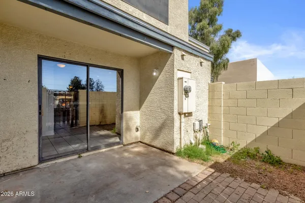 a view of a porch with a table and chairs and potted plants by side of it