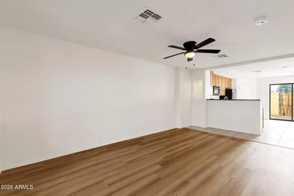 a view of a big room with wooden floor and a ceiling fan