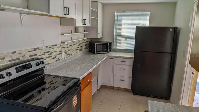 a kitchen with a stove refrigerator and microwave