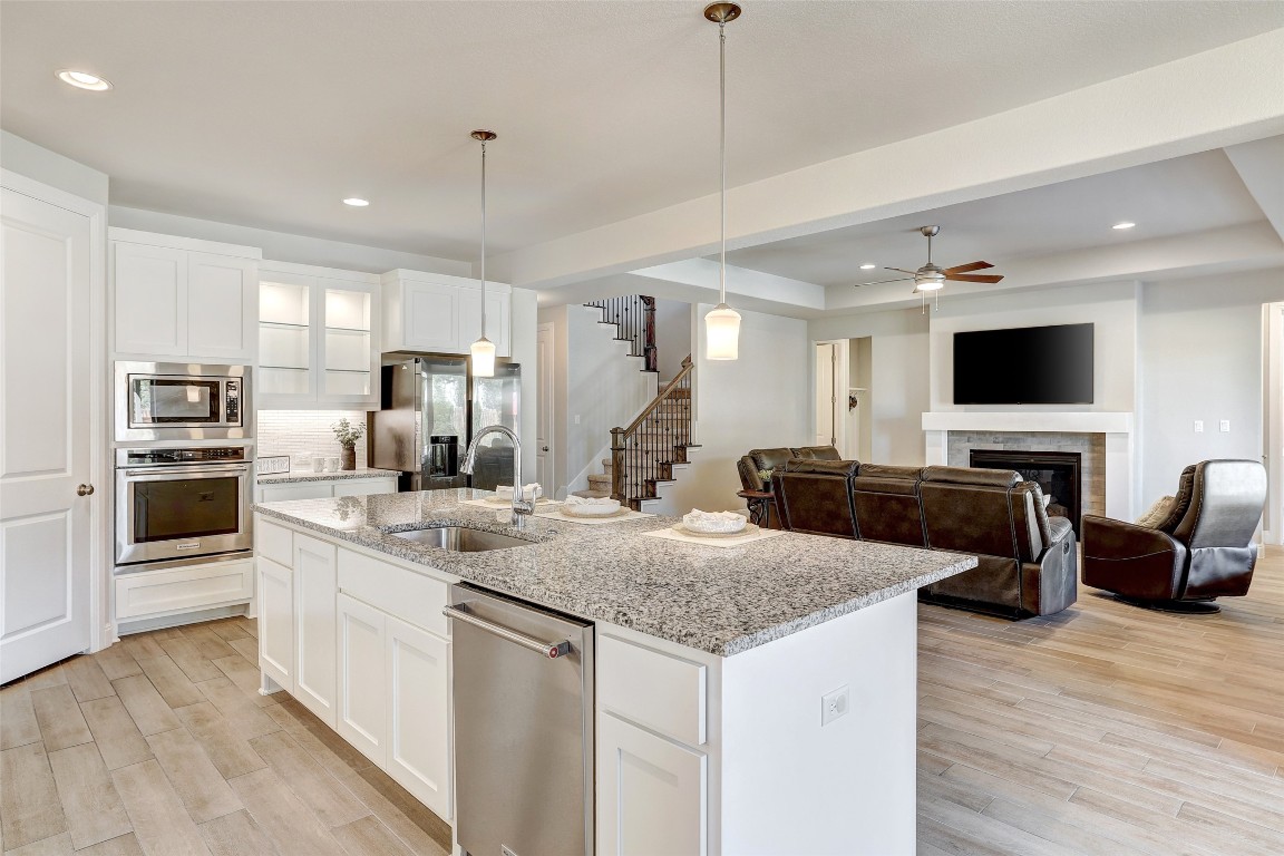 257 Axis Loop Georgetown, TX 78628 - Photo 11 of 40 a kitchen with kitchen island granite countertop a sink and microwave