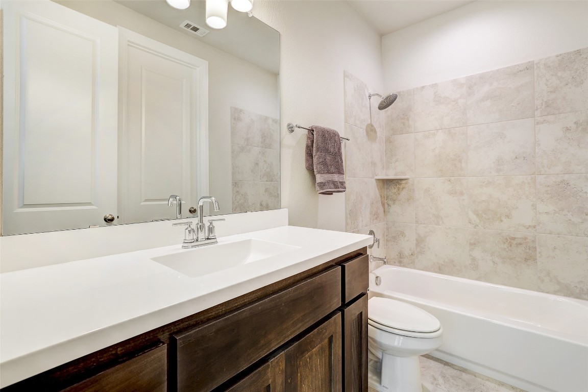 257 Axis Loop Georgetown, TX 78628 - Photo 28 of 40 a bathroom with a sink a toilet a mirror and bathtub