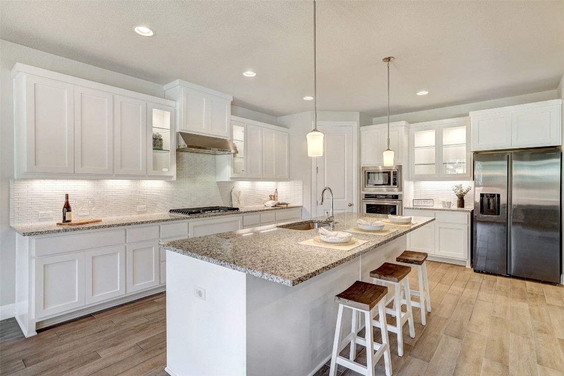 257 Axis Loop Georgetown, TX 78628 - Photo 8 of 40 a kitchen with stainless steel appliances granite countertop a sink refrigerator and cabinets