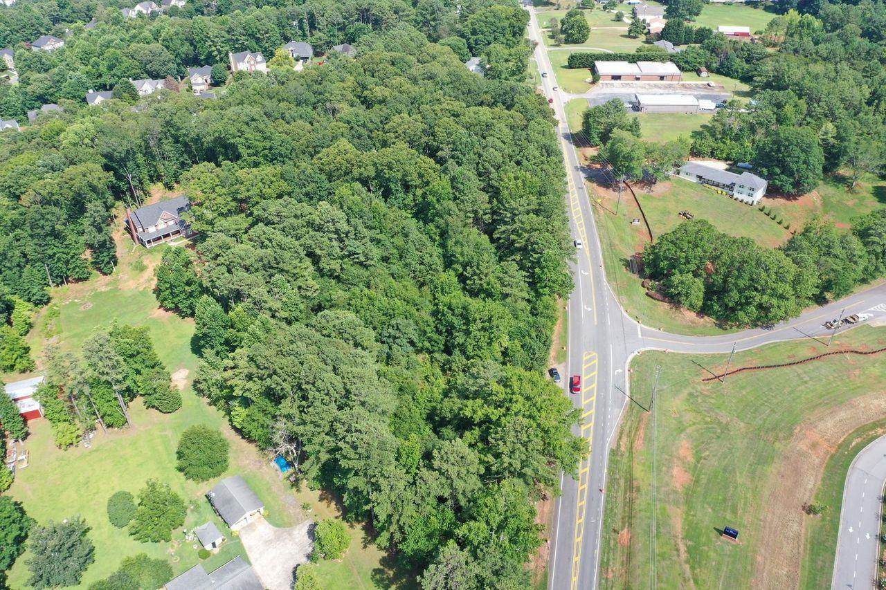 an aerial view of residential house with outdoor space and trees all around