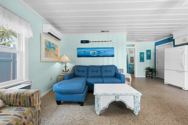 a living room with furniture a flat screen tv and kitchen view