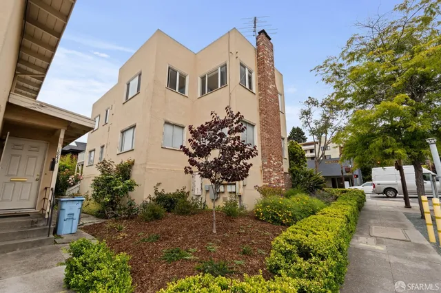 a front view of a house with a yard and potted plants