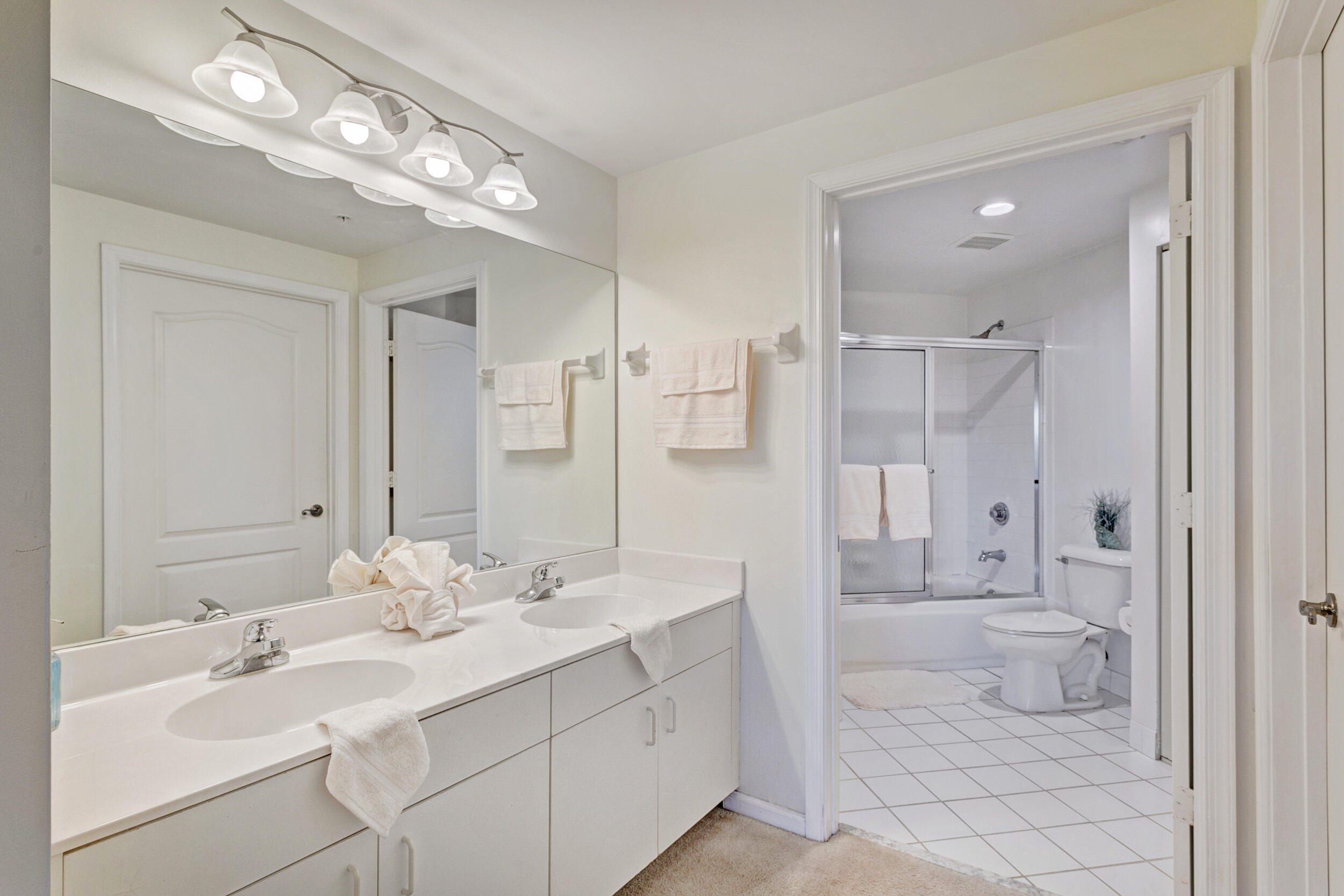 500 Uno Lago Drive, Unit 402 Juno Beach, FL 33408 - Photo 24 of 39 a spacious bathroom with a double vanity sink mirror and a shower
