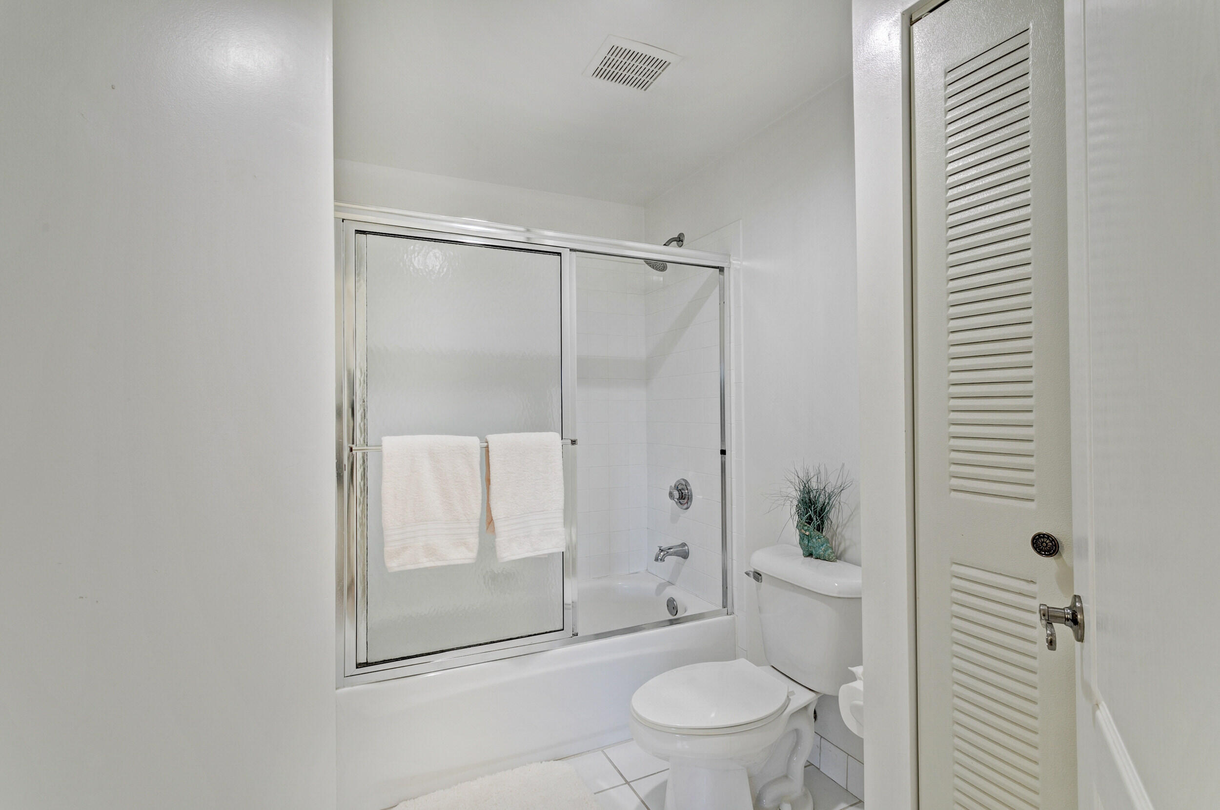 500 Uno Lago Drive, Unit 402 Juno Beach, FL 33408 - Photo 25 of 39 a bathroom with a granite countertop sink a toilet and shower