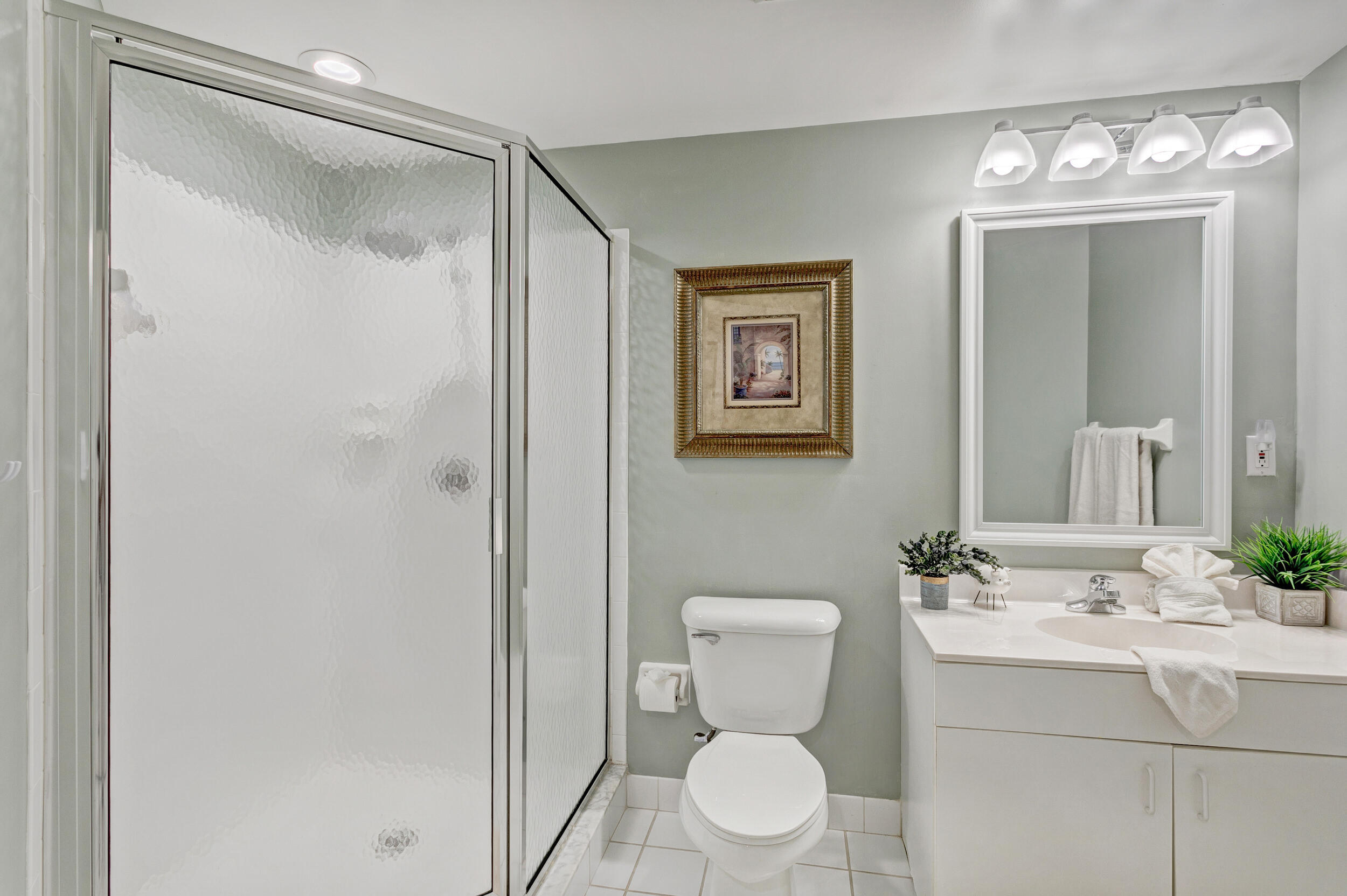500 Uno Lago Drive, Unit 402 Juno Beach, FL 33408 - Photo 29 of 39 a bathroom with a toilet sink and shower
