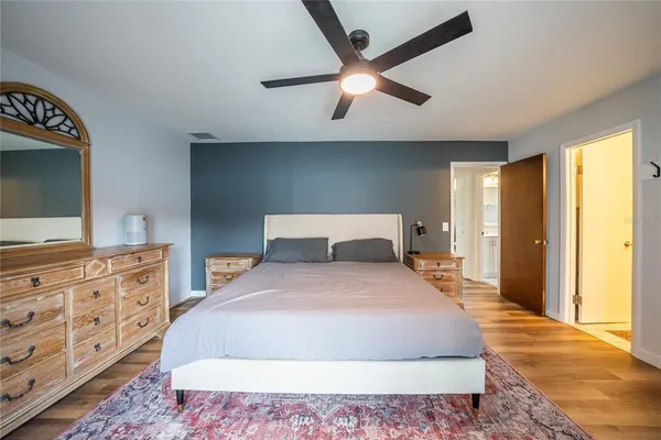 a bedroom with a large bed and a flat tv screen on dresser