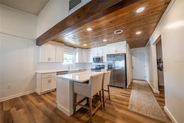 a kitchen with white cabinets stainless steel appliances and sink