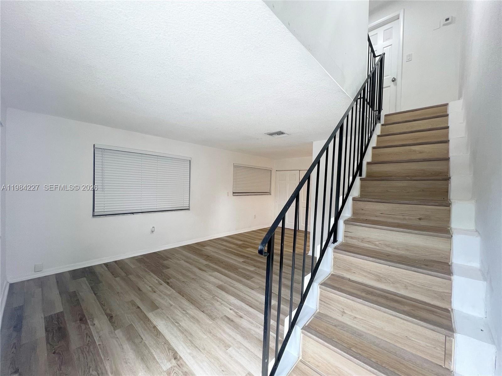 65 Northeast 59th Street, Unit 2 Miami, FL 33137 - Photo 1 of 14 a view of staircase with wooden floor and white walls