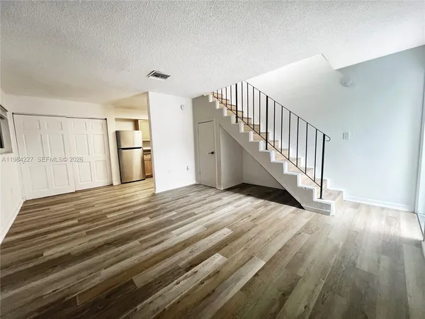 a view of a room with wooden floor and stairs