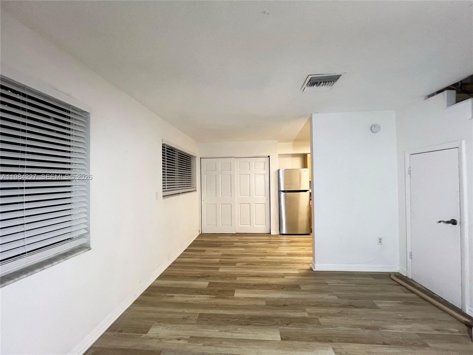 65 Northeast 59th Street, Unit 2 Miami, FL 33137 - Photo 3 of 14 a view of an empty room with wooden floor and a window