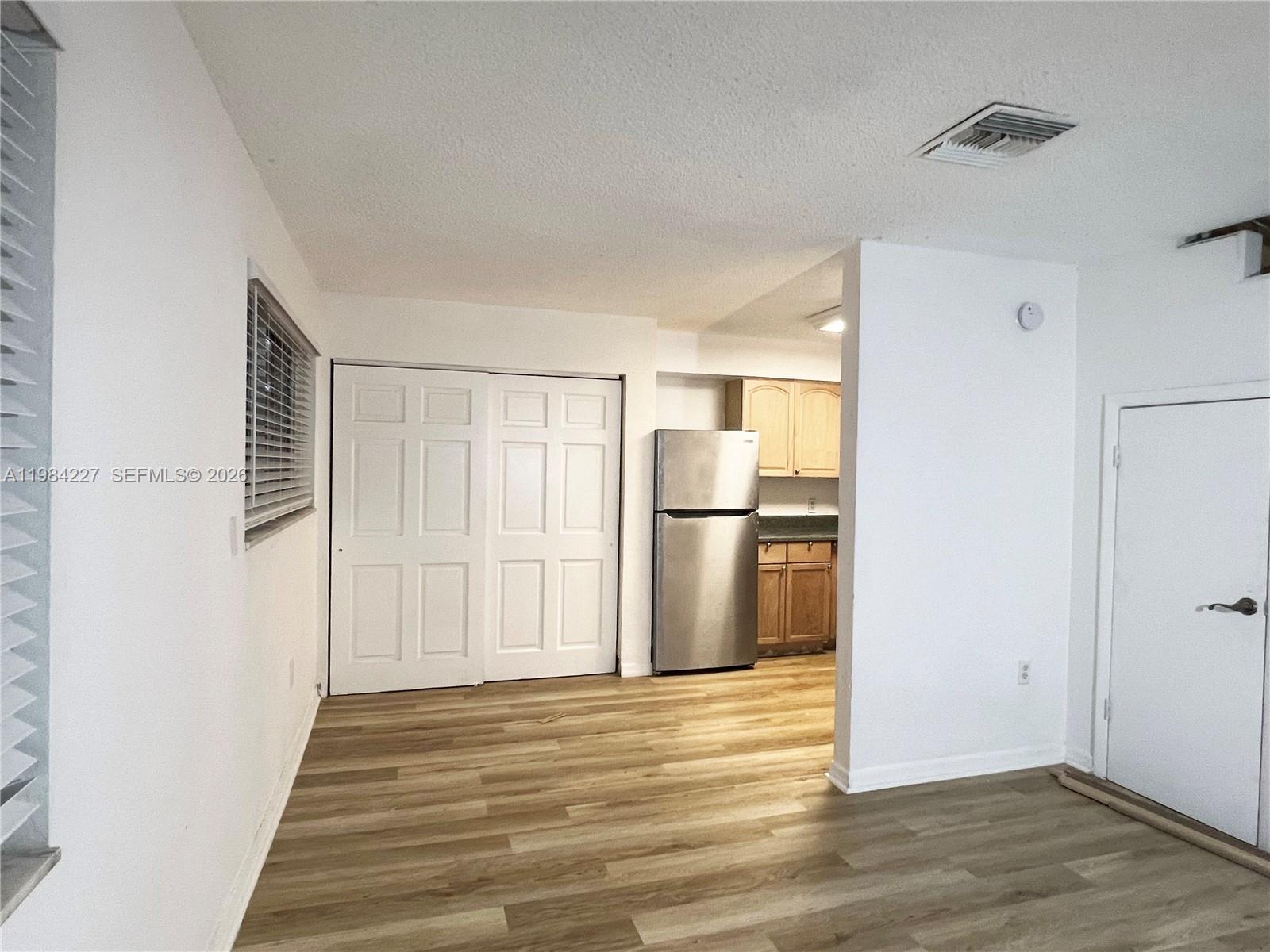 65 Northeast 59th Street, Unit 2 Miami, FL 33137 - Photo 4 of 14 a view of a kitchen with wooden floor and a hallway