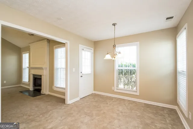 a view of an empty room with a fireplace and a window
