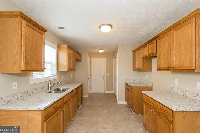 a large kitchen with stainless steel appliances granite countertop a sink stove and cabinets