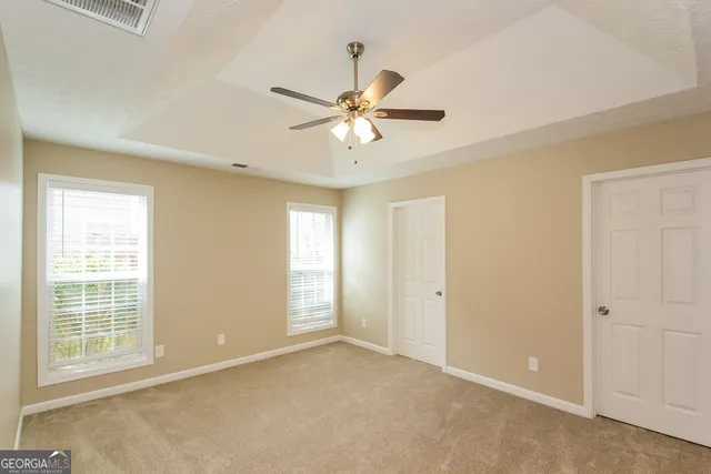 a view of a room with a ceiling fan and a window