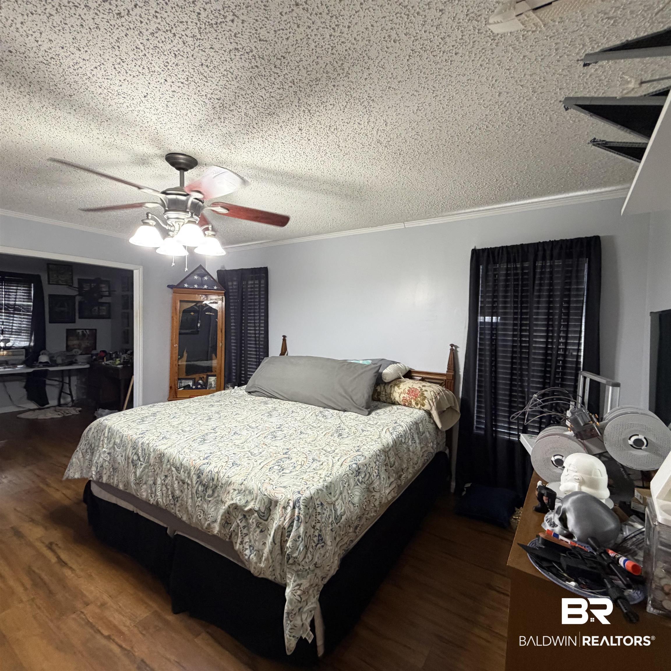 447 Sugar Hill Road Monroeville, AL 36460 - Photo 18 of 27 Bedroom featuring a ceiling fan, crown molding, dark wood finished floors, and a textured ceiling