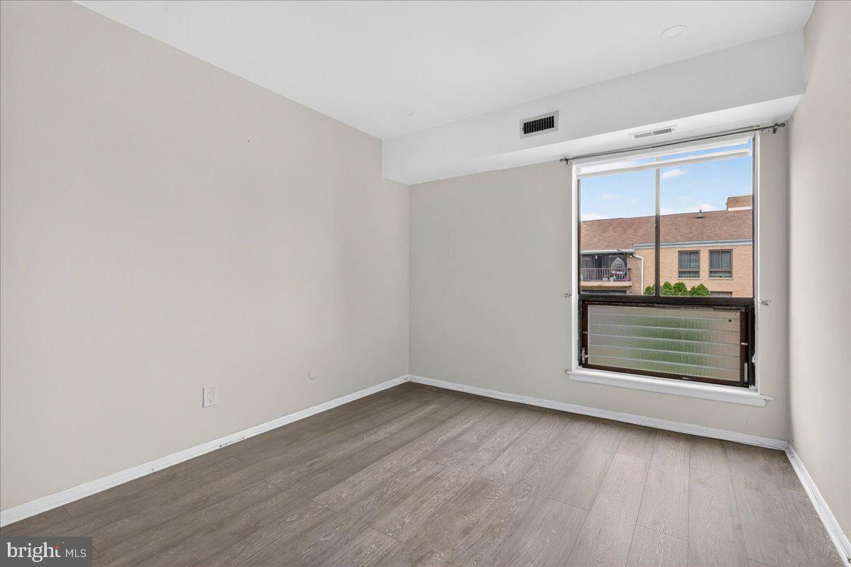 8930 Krewstown Road, Unit 310 Philadelphia, PA 19115 - Photo 21 of 32 an empty room with wooden floor and windows