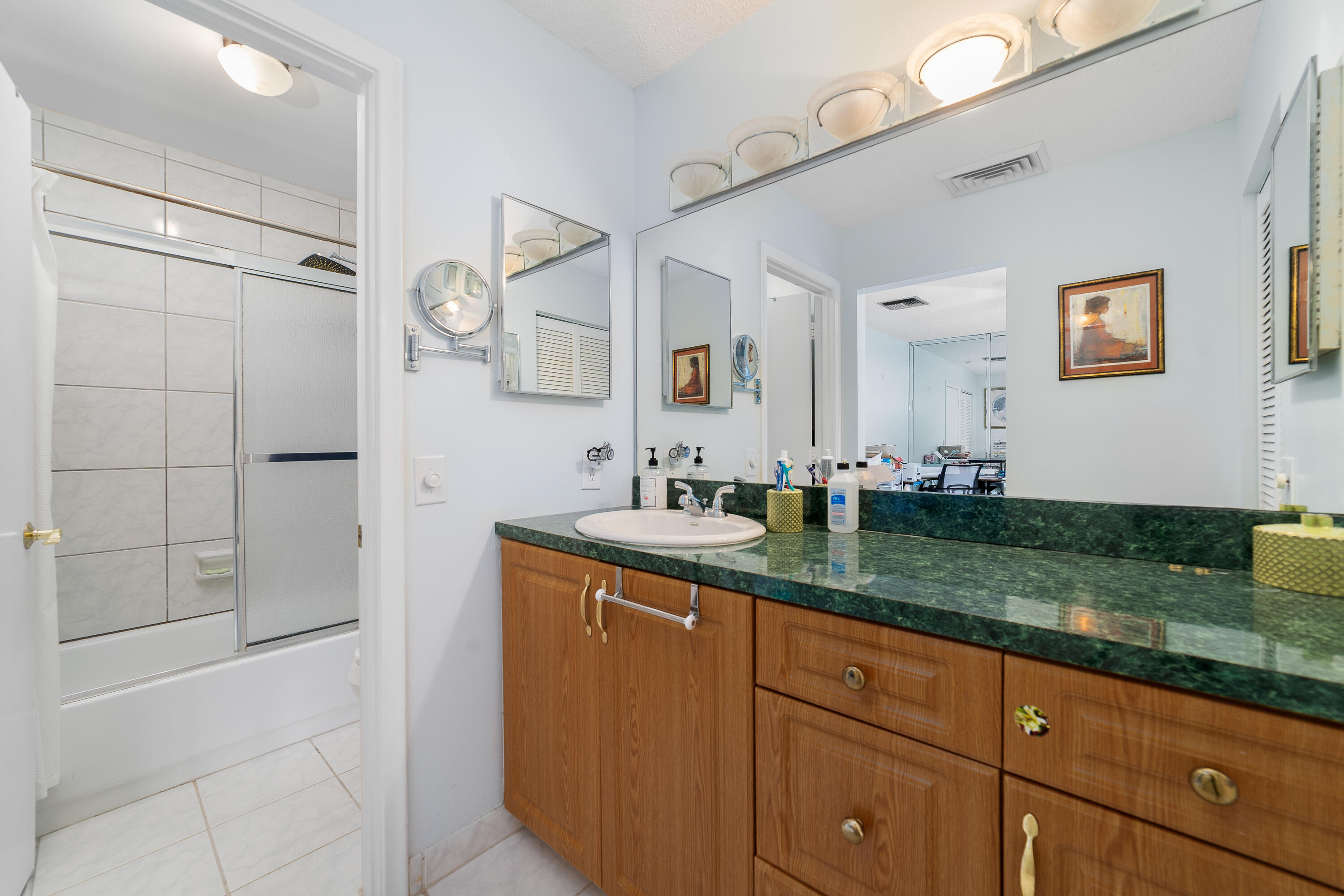 21160 Juego Circle, Unit 13C Boca Raton, FL 33433 - Photo 17 of 41 a bathroom with a granite countertop sink and a mirror