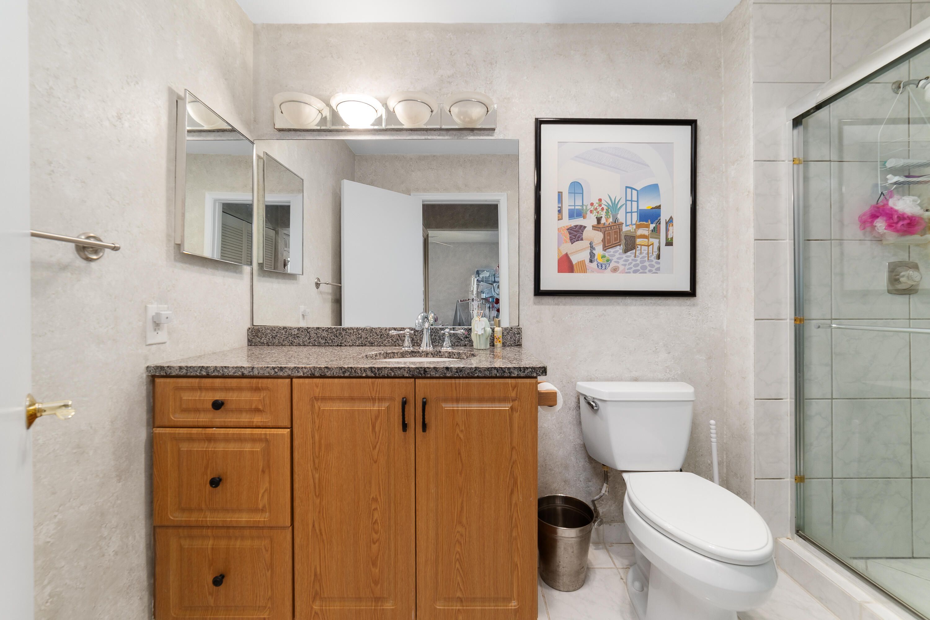 21160 Juego Circle, Unit 13C Boca Raton, FL 33433 - Photo 20 of 41 a bathroom with a toilet a sink and mirror