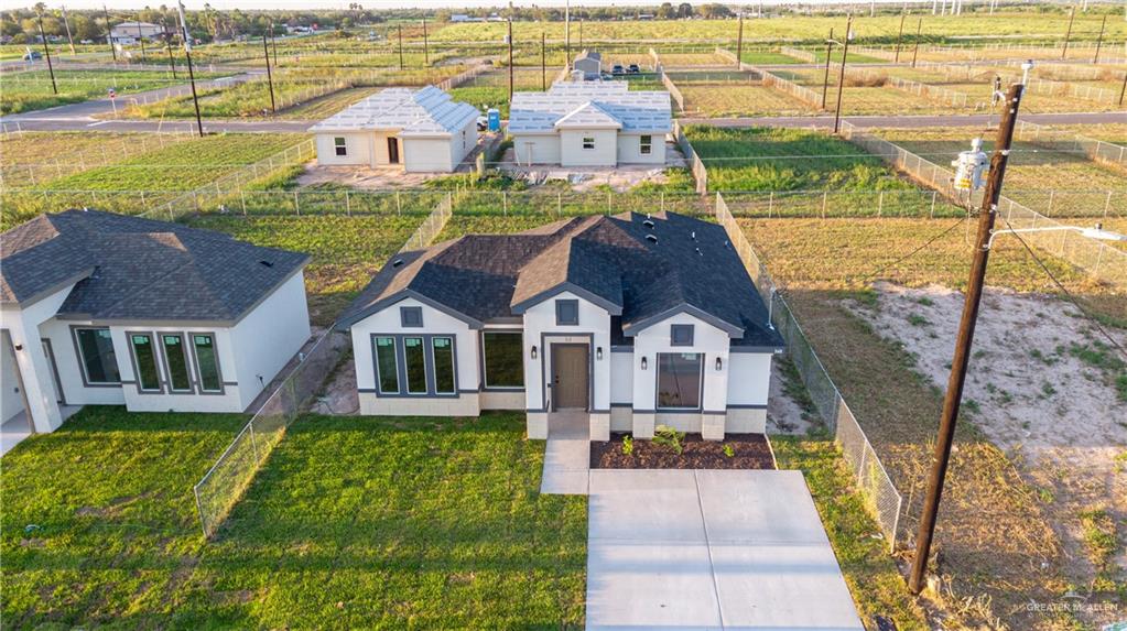 348 Merida Street Donna, TX 78537 - Photo 18 of 19 a front view of a house with a big yard and potted plants