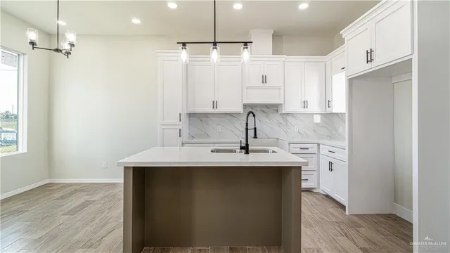 a kitchen with kitchen island a sink stainless steel appliances and cabinets