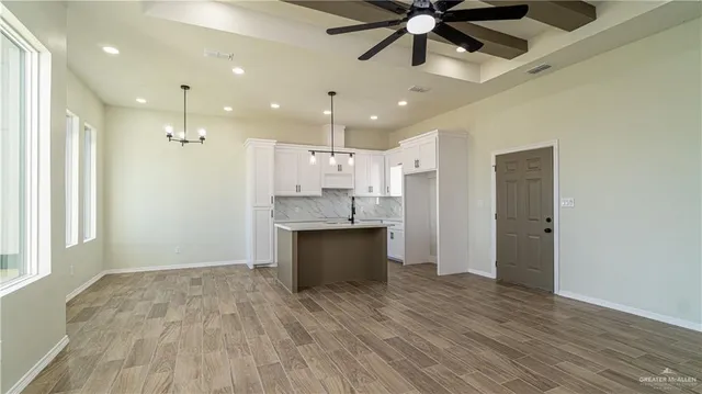 a large kitchen with a refrigerator a sink stainless steel appliances and cabinets