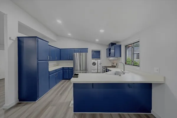 a kitchen with stainless steel appliances a refrigerator and wooden cabinets