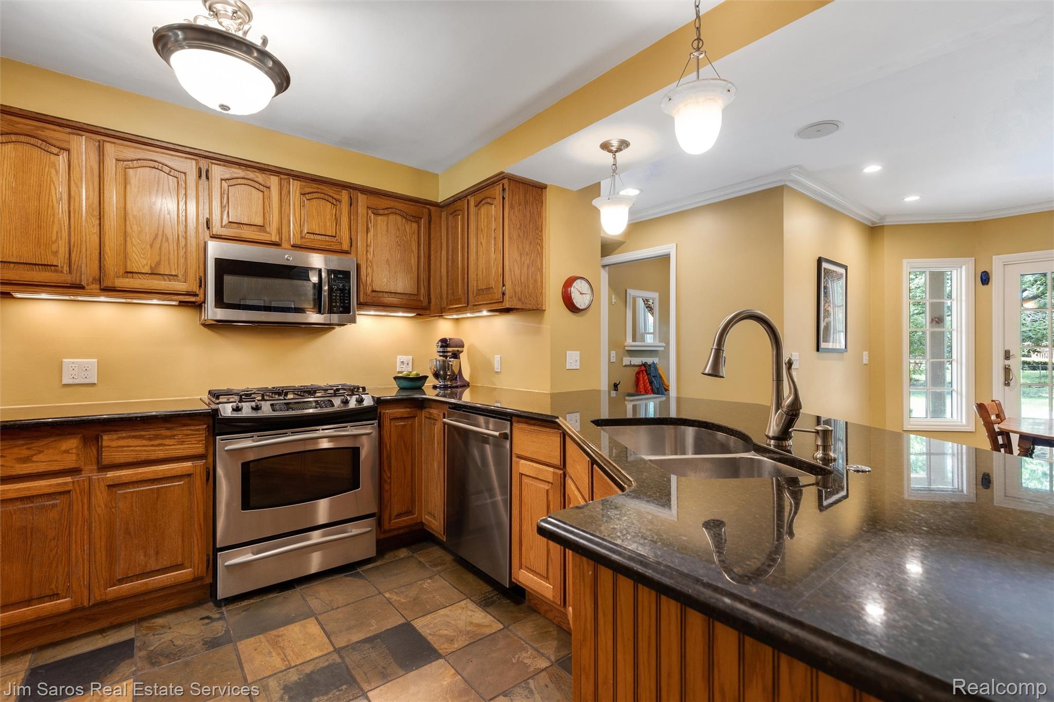 820 Westchester Road Grosse Pointe, MI 48230 - Photo 12 of 33 Kitchen with wood finish cabinets, stainless steel appliances, a peninsula, pendant lighting, and crown molding