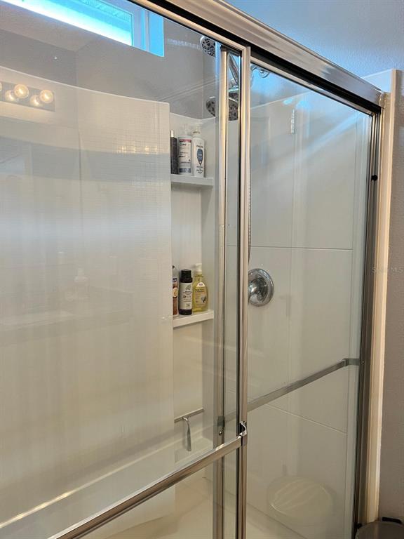 1404 Tawny Ridge Road Kissimmee, FL 34744 - Photo 15 of 21 a bathroom with a glass shower door