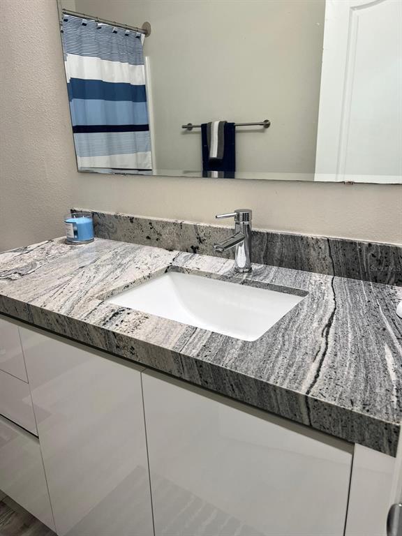 1404 Tawny Ridge Road Kissimmee, FL 34744 - Photo 16 of 21 a bathroom with a granite countertop sink and a mirror