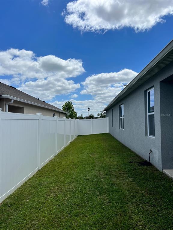 1404 Tawny Ridge Road Kissimmee, FL 34744 - Photo 18 of 21 a backyard of a house with lots of green space