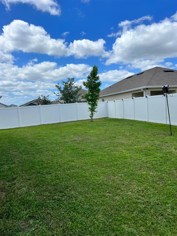 1404 Tawny Ridge Road Kissimmee, FL 34744 - Photo 4 of 21 a view of a backyard with grass and a white house