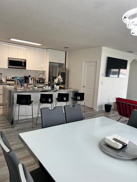 1404 Tawny Ridge Road Kissimmee, FL 34744 - Photo 5 of 21 a living room with furniture a flat screen tv and kitchen view