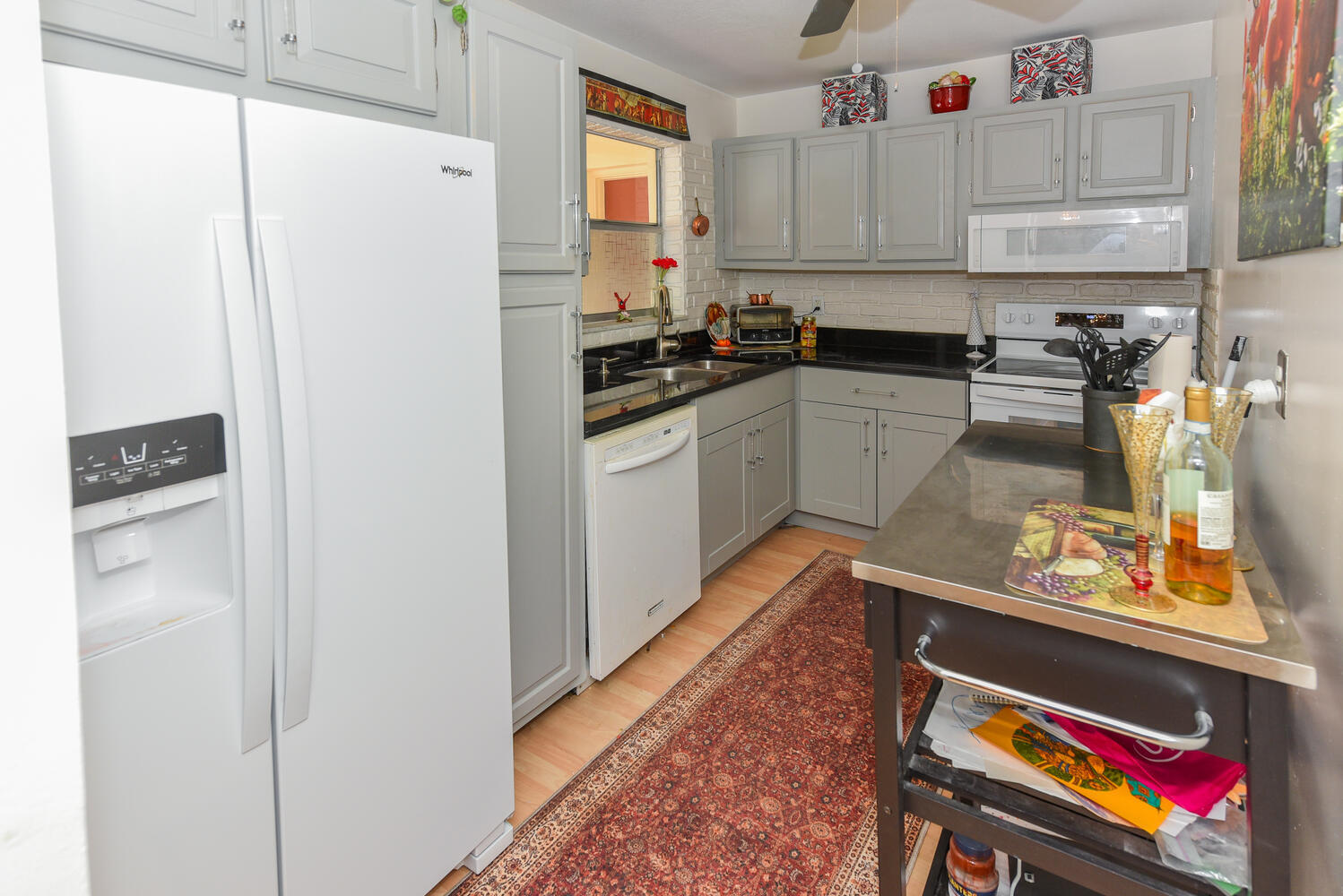 477 Lake Dora Drive West Palm Beach, FL 33411 - Photo 9 of 28 a kitchen with stainless steel appliances granite countertop a refrigerator and a stove top oven