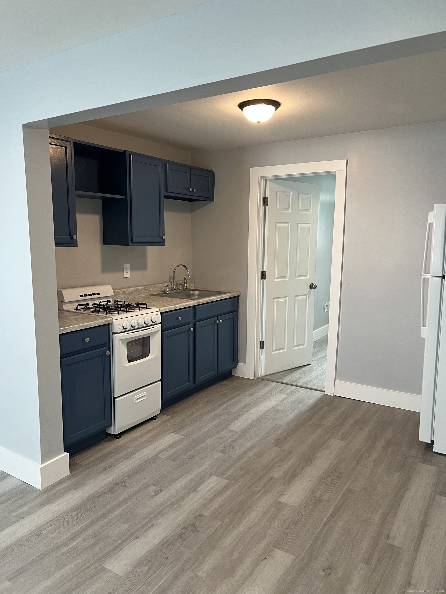a view of kitchen with stainless steel appliances granite countertop a stove a sink and a refrigerator