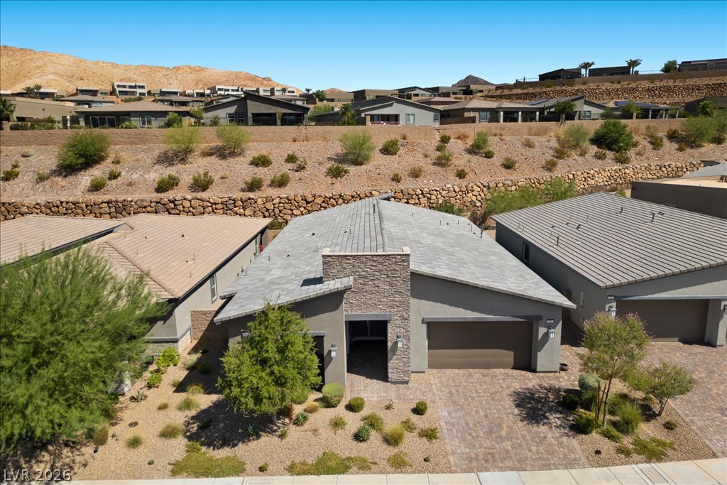 20 Charlotte Ridge Place Henderson, NV 89011 - Photo 32 of 33 Modern desert architecture with a brick paver driveway and natural landscaping.