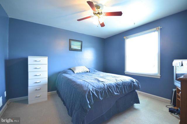130 Garden Ridge Road Baltimore, MD 21228 - Photo 15 of 16 a bedroom with a bed and a chandelier
