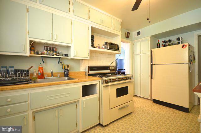 130 Garden Ridge Road Baltimore, MD 21228 - Photo 7 of 16 a kitchen with stainless steel appliances granite countertop a sink a stove a refrigerator and white cabinets