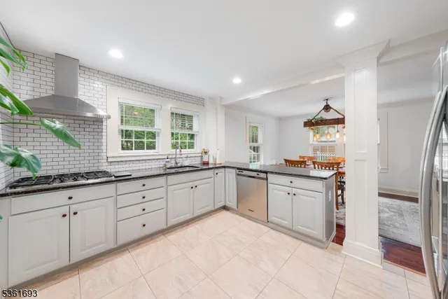 a kitchen with granite countertop a refrigerator and a sink