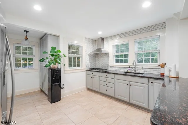 a kitchen with granite countertop a sink and cabinets