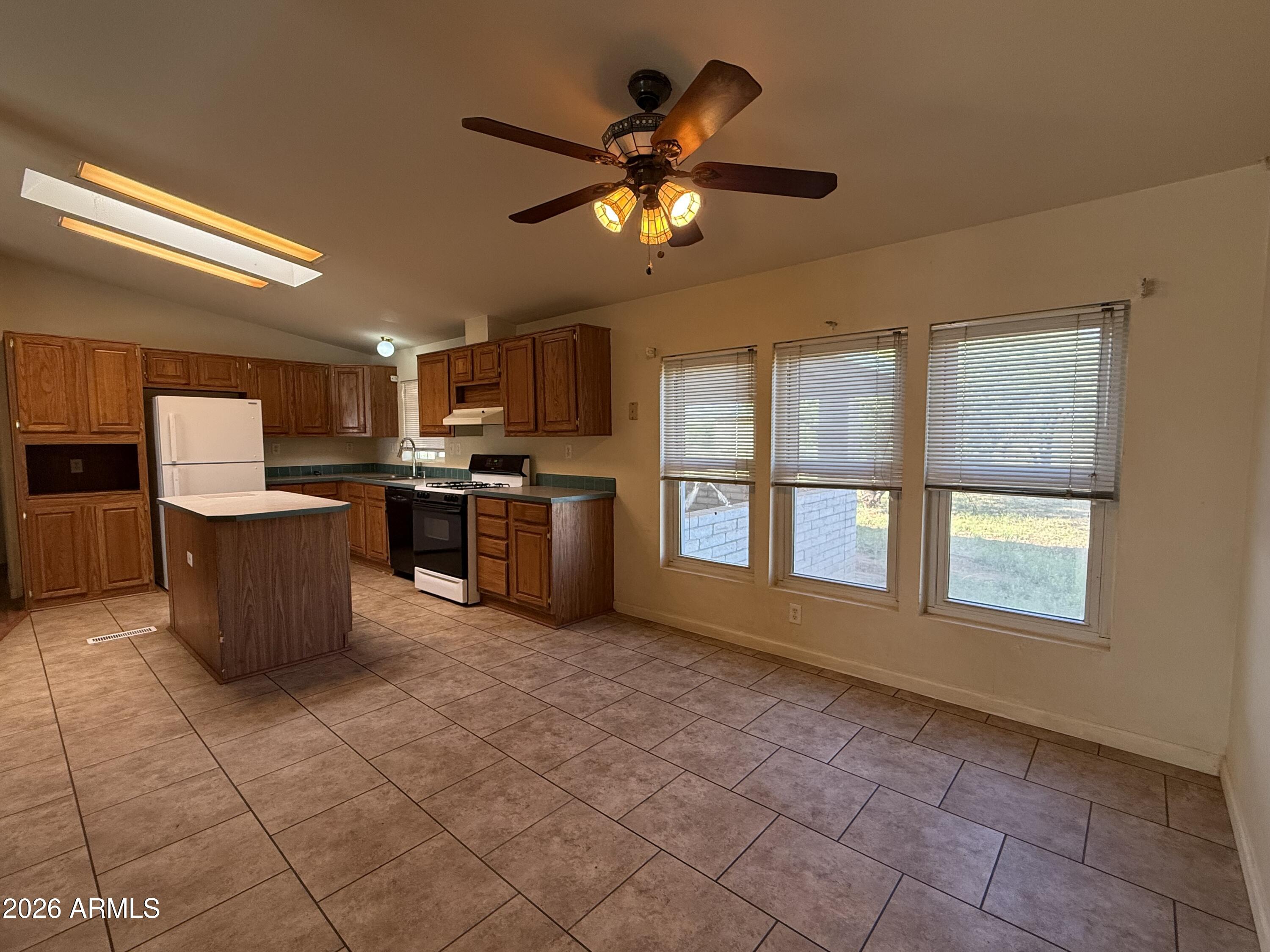 6206 South Ranch Road Hereford, AZ 85615 - Photo 4 of 14 a kitchen with stainless steel appliances granite countertop a stove top oven a sink a dining table and chairs