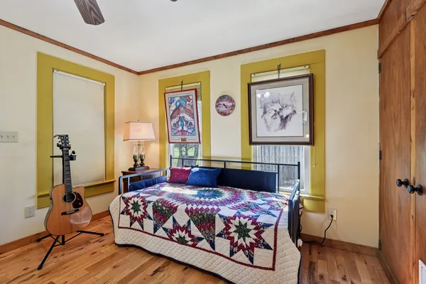 a bedroom with a bed and wooden floor