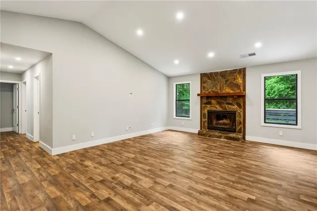 a view of empty room with a fireplace and window