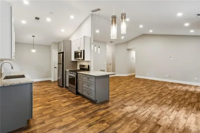 a large kitchen with kitchen island a sink stainless steel appliances and cabinets