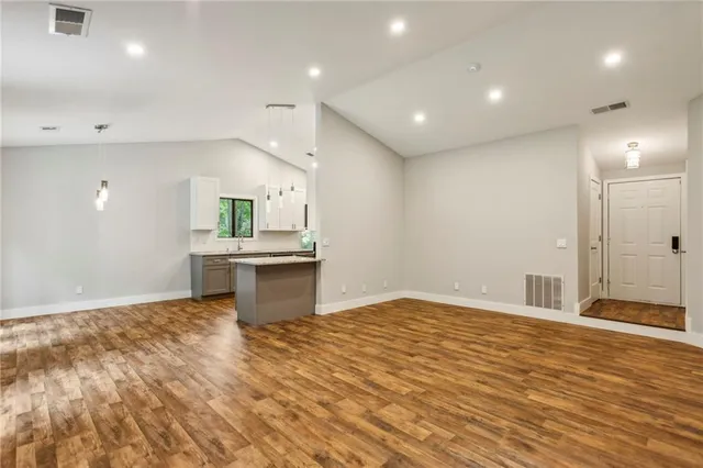 an empty room with windows and fireplace