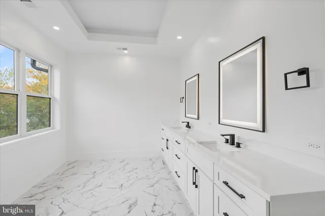 a bathroom with double vanity sink a mirror and a shower
